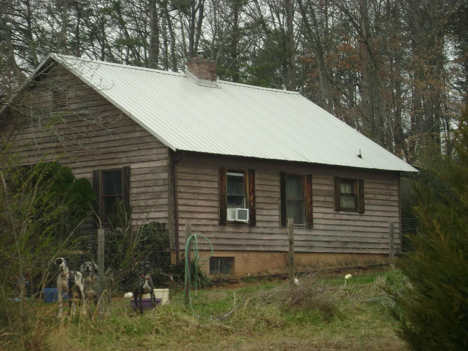 White metal roof on an old wood sided farmhouse, from a Metal Roof Installation job in Carney
